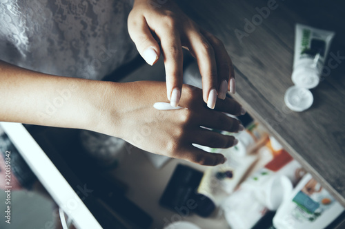 Female hands applying cream