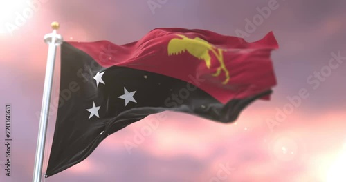 Flag of Papua New Guinea waving at wind at sunset in slow, loop photo