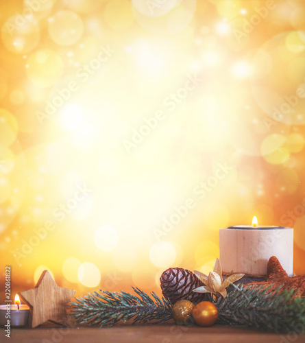 Weihnachtliche Dekoration mit leuchtenden Hintergrund und brennender Kerze 