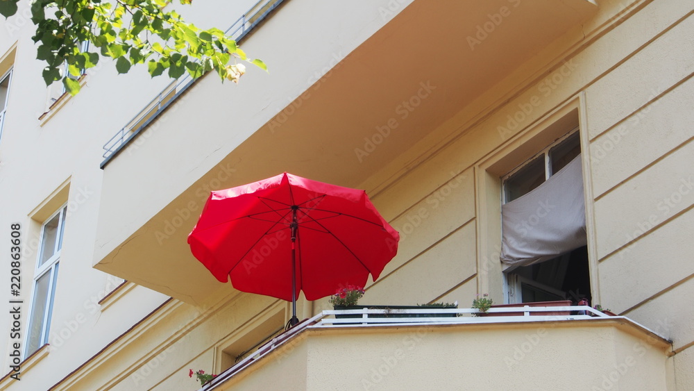 Fototapeta premium Berlin-Mitte: Lato na balkonie, czerwony parasol