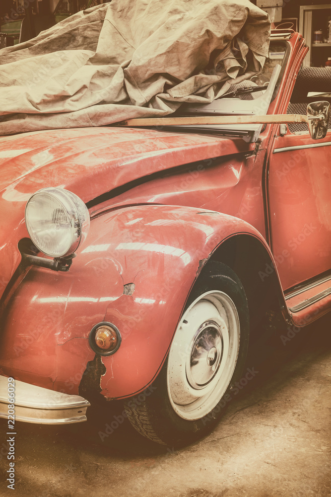 Fototapeta premium Vintage weathered classic red car in an old garage