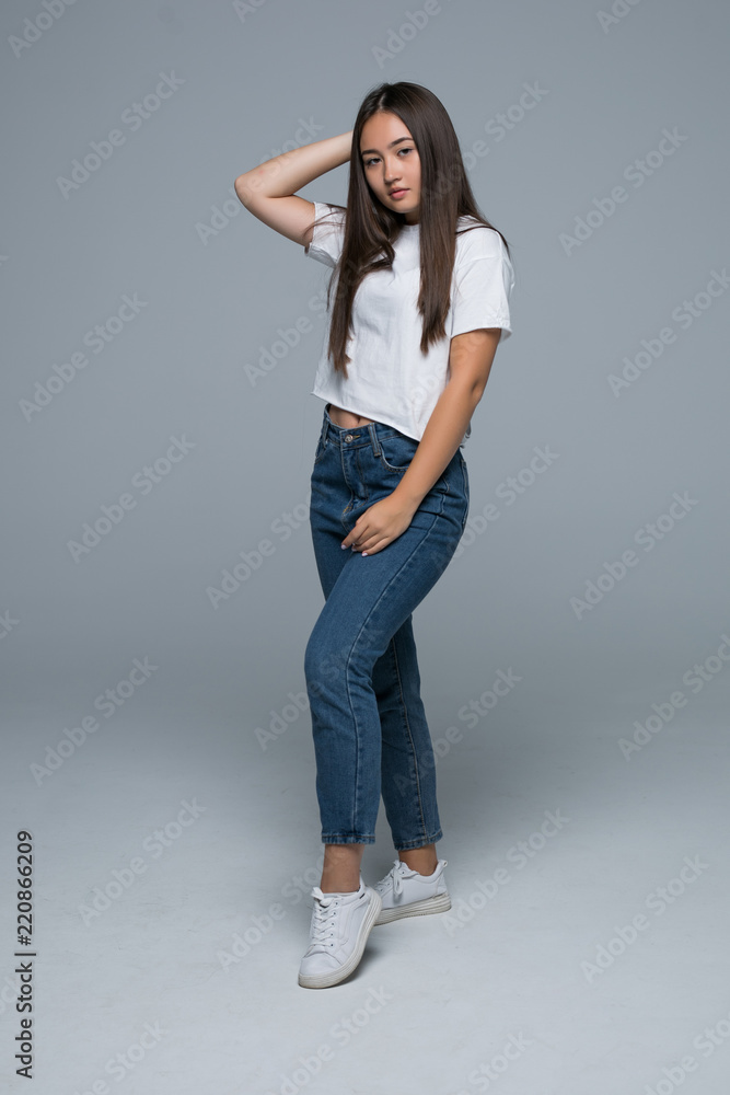 Full body portrait of happy smiling beautiful asian young woman, isolated over gray background Full body portrait of happy smiling beautiful asian young woman, isolated over gray background