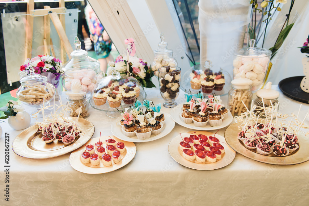 Candy bar. Table with sweets at the wedding (cupcakes, cakes, marshmallows)