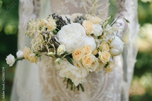Beautiful wedding bouquet for the bride with peonies and white roses and eustoma