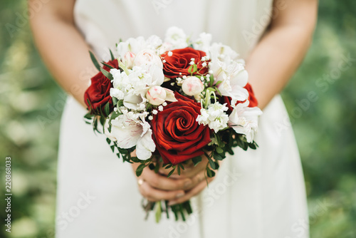 Beautiful wedding bouquet for the bride with red and white roses and eustoma