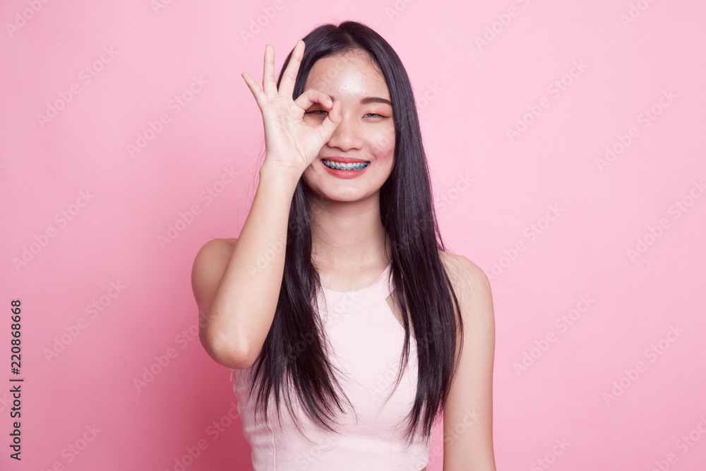 Beautiful young Asian woman show OK sign over her eye. Beautiful young Asian woman show OK sign over her eye.