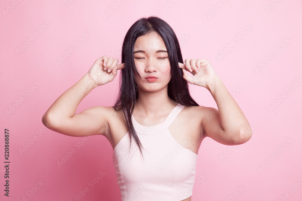 Young Asian woman block both ears with fingers. Young Asian woman block both ears with fingers.