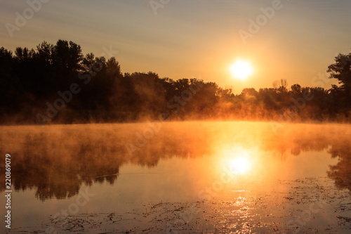 View of river in the mist at sunrise. Fog over river at morning