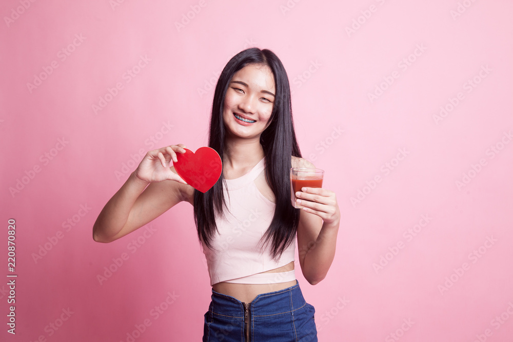 Young Asian woman with tomato juice and red heart. Young Asian woman with tomato juice and red heart.