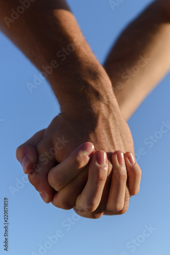 two male hands against the sky