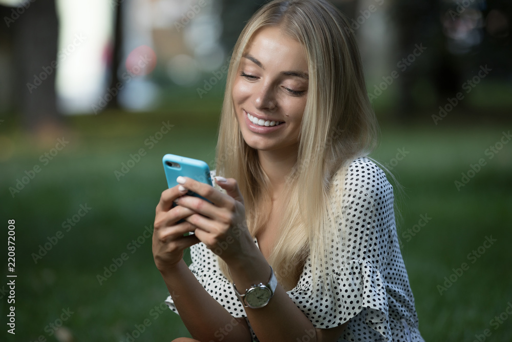 Woman using phone on grass