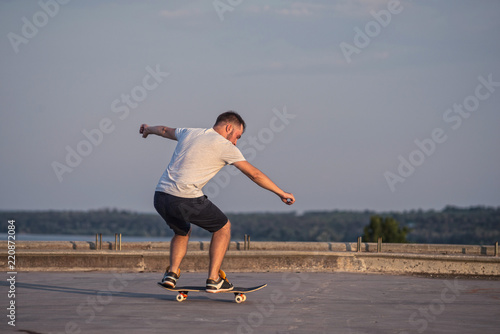 Skateboarder doing an ollie trick on background of blue sky.