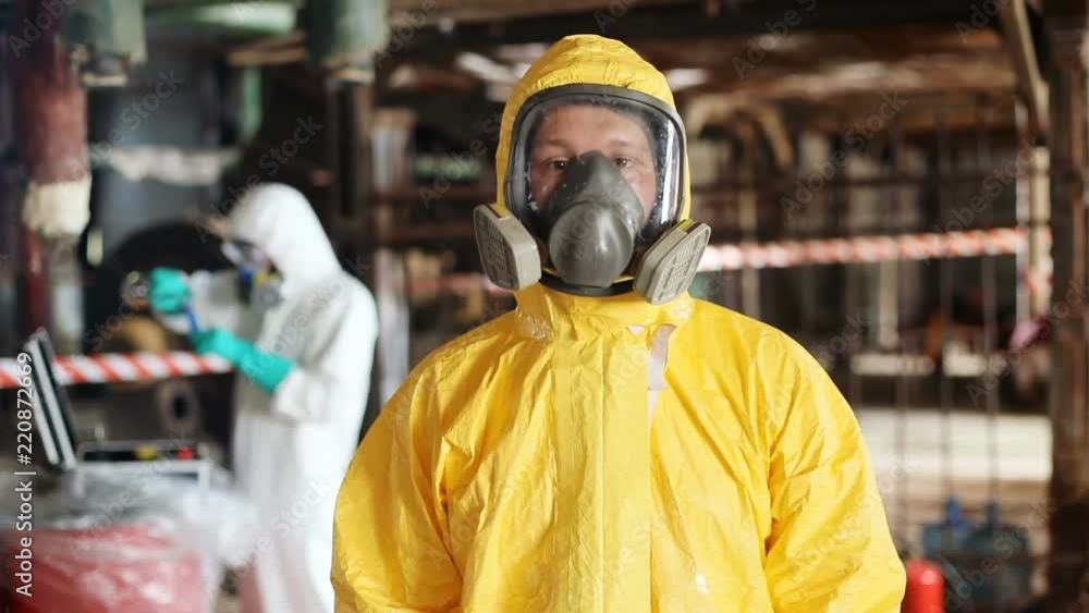 Young Caucasian man in yellow suit looking at camera. Portrait of Slavic guy with gas mask. Radiation exposure. Invisible danger. Close-up. Young Caucasian man in yellow suit looking at camera. Portrait of Slavic guy with gas mask. Radiation exposure. Invisible danger. Close-up.