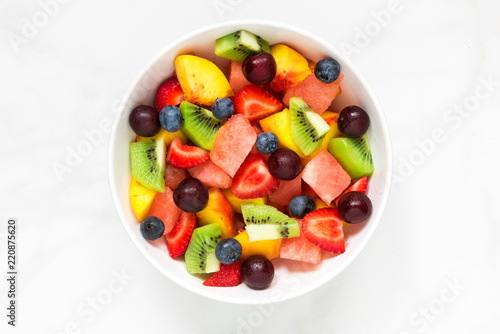 Bowl of healthy fresh fruit salad on white marble background. healthy food