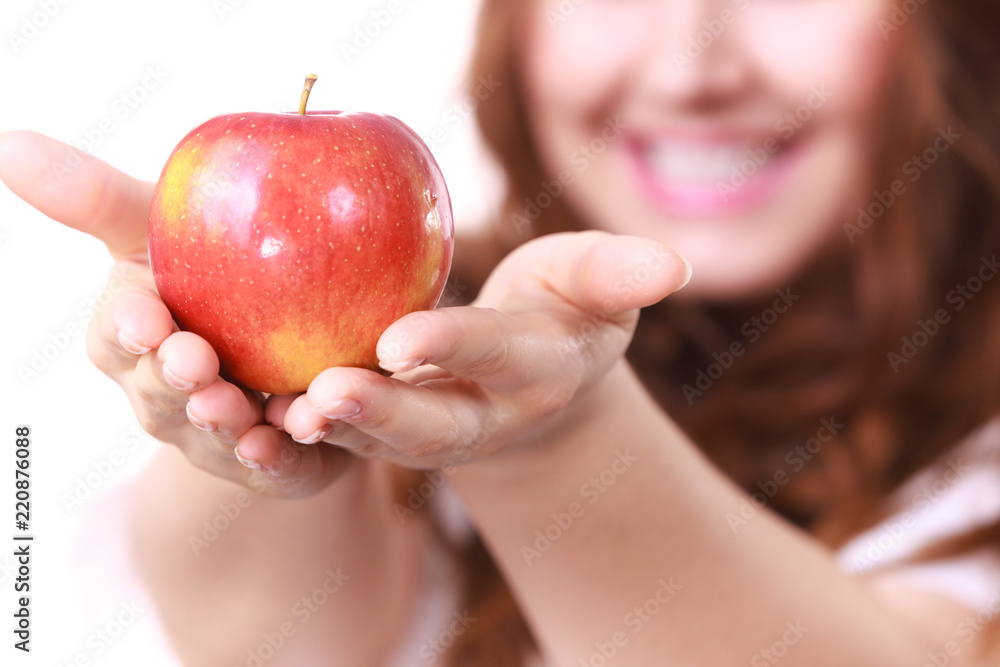 Woman holds red apple, focus on fruit Woman holds red apple, focus on fruit