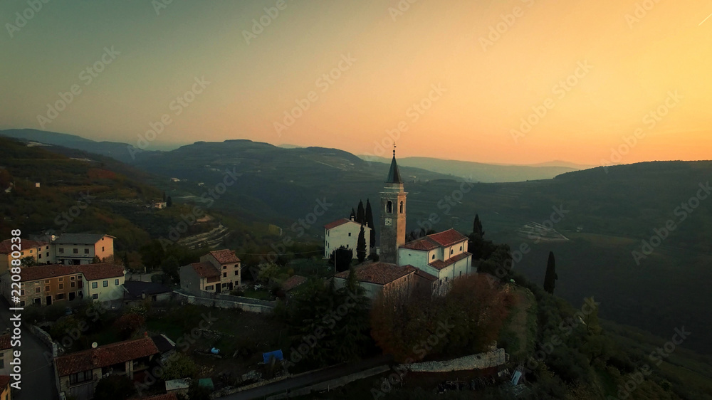 Fototapeta premium Aerial view of a typical small village in the Italian hills at sunset.