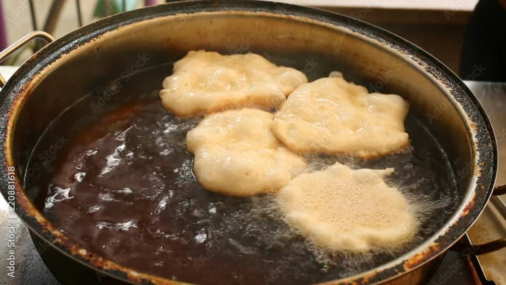 The doughnuts from dough are placed in boiling oil in a pan The doughnuts from dough are placed in boiling oil in a pan