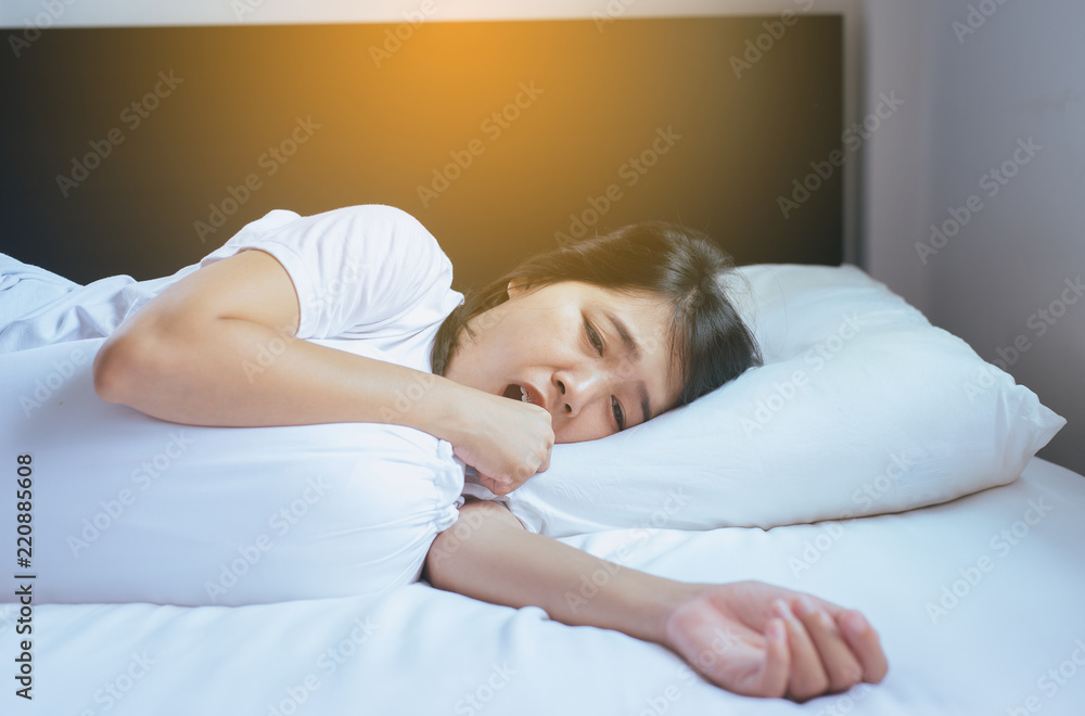 Asian woman coughing on her bed,Concept of health Asian woman coughing on her bed,Concept of health