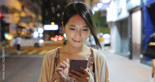 Canvas Print Woman use of smart phone in the city at night
