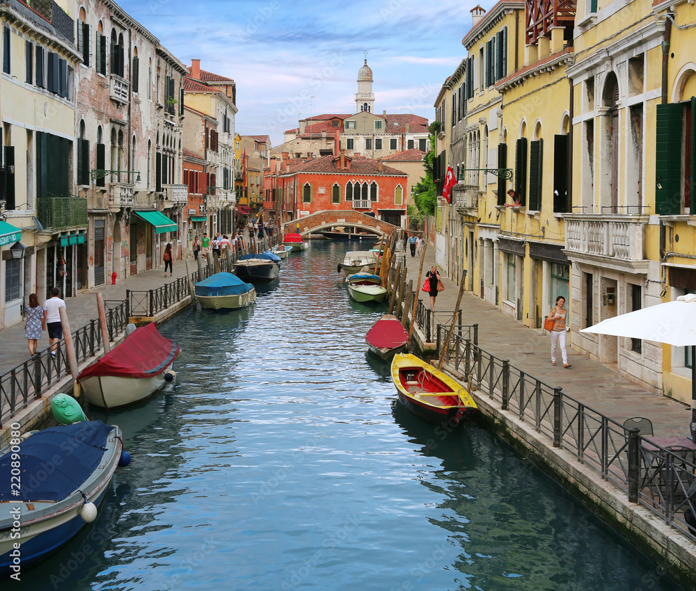 Charming Venetian canal street with colorful boats