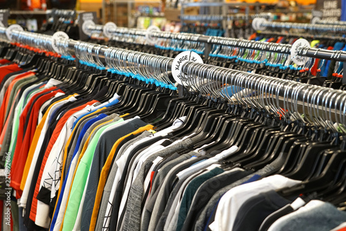 rows of clothes hanging in the rack of store