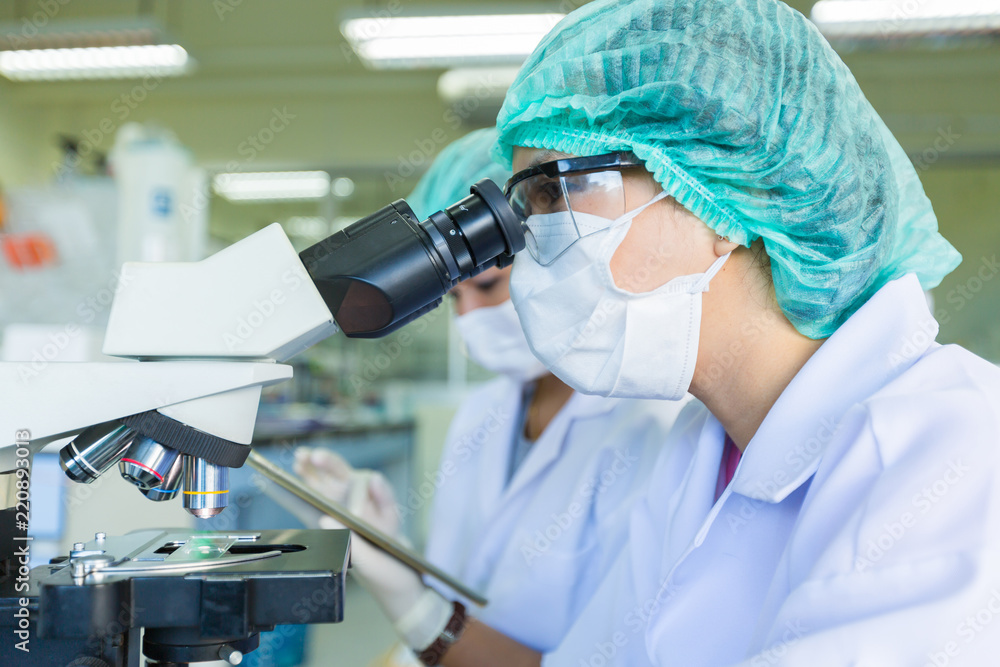 Scientist using a microscope in a laboratory, Concept science and technology