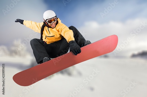 Snowboarder flying on his board with cloud on background