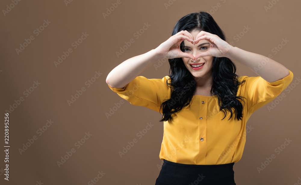Woman making a heart shaped gesture with her hands Woman making a heart shaped gesture with her hands