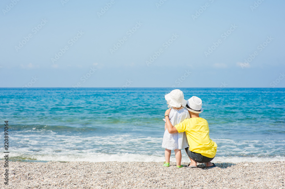 Boy embracing baby girl on the beach on summer holidays. concept of summer family vacation. Space for text Boy embracing baby girl on the beach on summer holidays. concept of summer family vacation. Space for text
