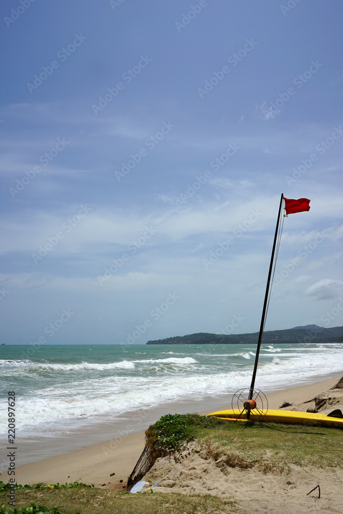 Red flag on the Beautiful beach landscape with heavy wave in Phuket Red flag on the Beautiful beach landscape with heavy wave in Phuket