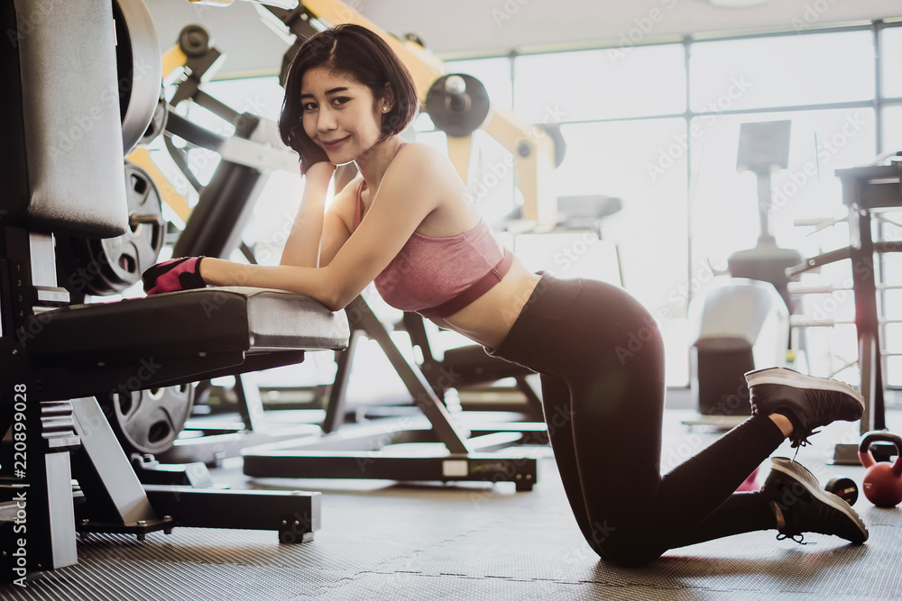 Attractive fit woman relaxing after workout in gym fitness. Portrait sport and Healthy concept. Attractive fit woman relaxing after workout in gym fitness. Portrait sport and Healthy concept.