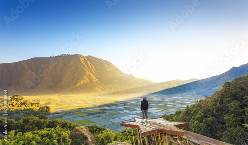 Traveller enjoying views wonderful farmland scenery at Sembalun near Rinjani volcano in Lombok, Indonesia. Traveling, freedom and active lifestyle concept.