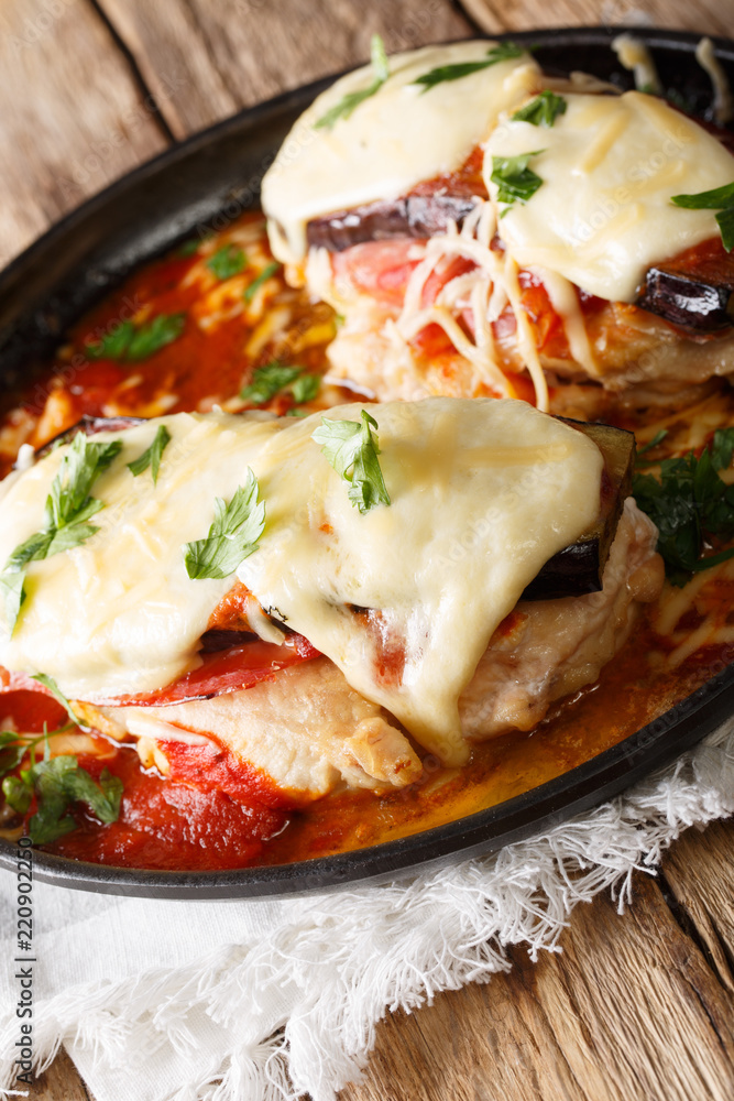 Italian chicken fillet of Sorrentino with eggplant, ham, cheese and marinara sauce close-up on a plate. vertical Italian chicken fillet of Sorrentino with eggplant, ham, cheese and marinara sauce close-up on a plate. vertical