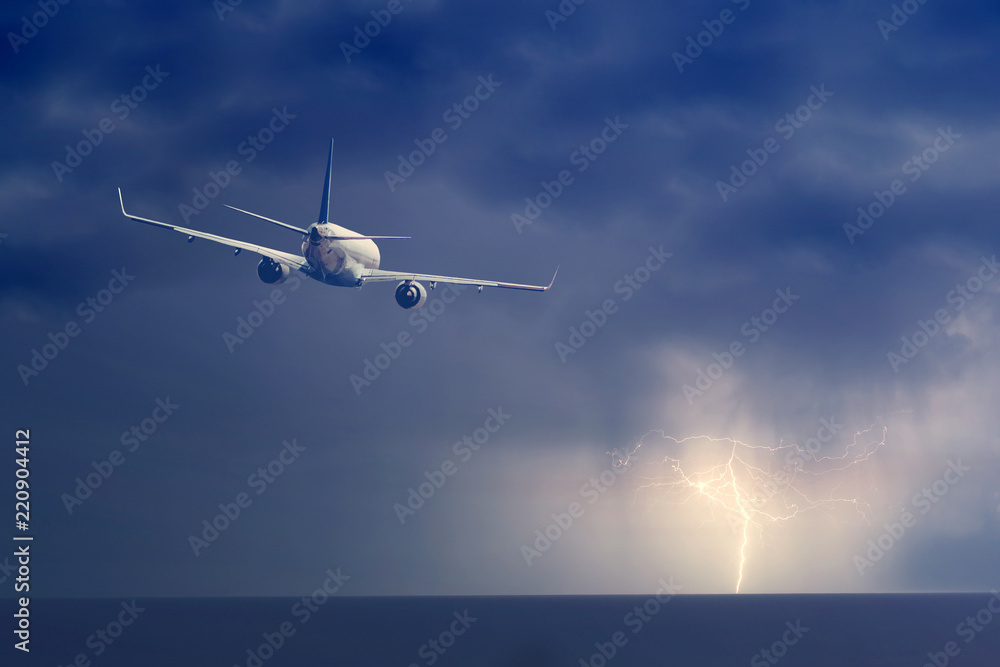 Fototapeta premium Passenger airplane flying above sea on stormy sky with dark clouds and lightnings.