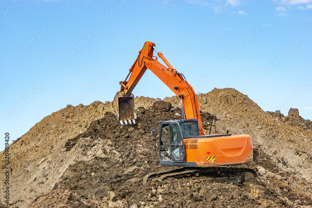 Excavator at the construction site pours a pile of soil Excavator at the construction site pours a pile of soil