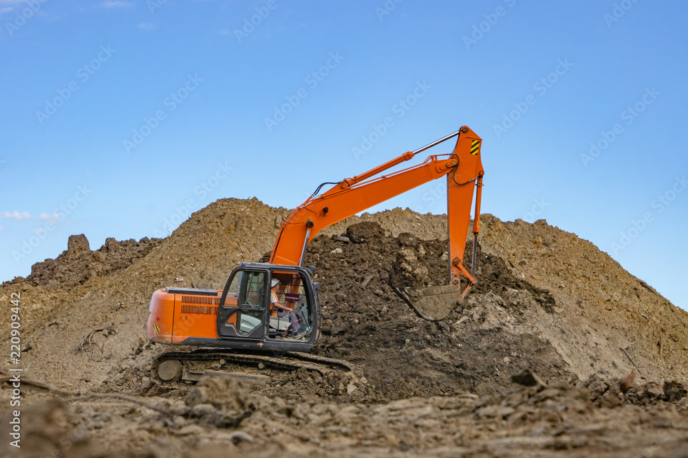 Excavator at the construction site pours a pile of soil Excavator at the construction site pours a pile of soil