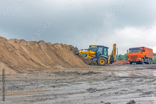Bulldozer at a construction site forms a pile of sand