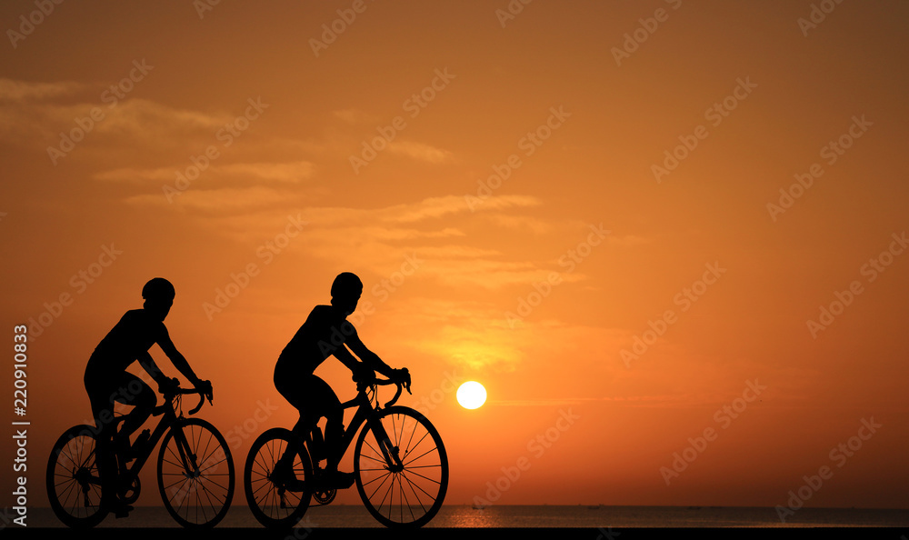 Obraz premium Silhouette group friend and bike relaxing on blurry sunset background.