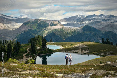 Принти на полотні People hiking in mountains near beautiful alpine lakes and glaciers