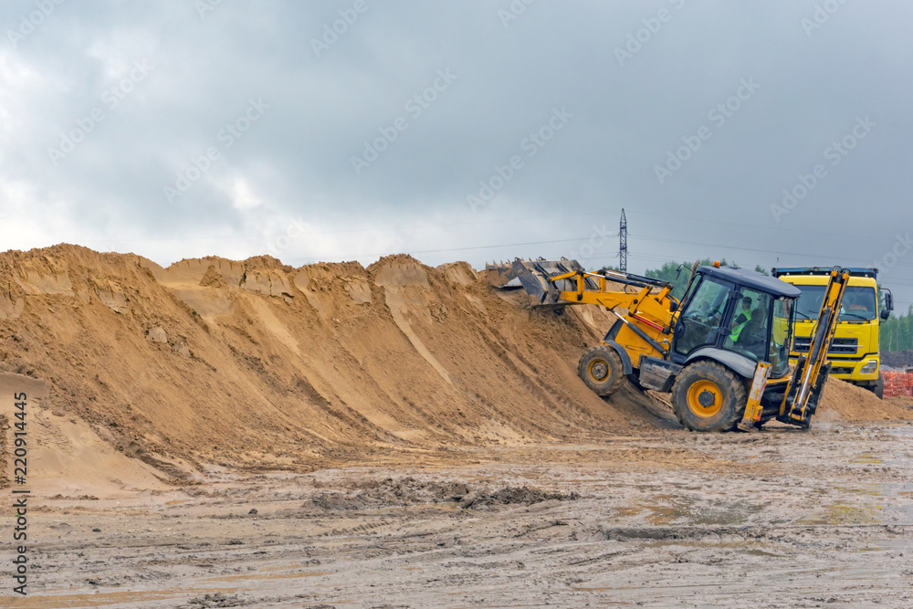 Bulldozer at a construction site forms a pile of sand Bulldozer at a construction site forms a pile of sand