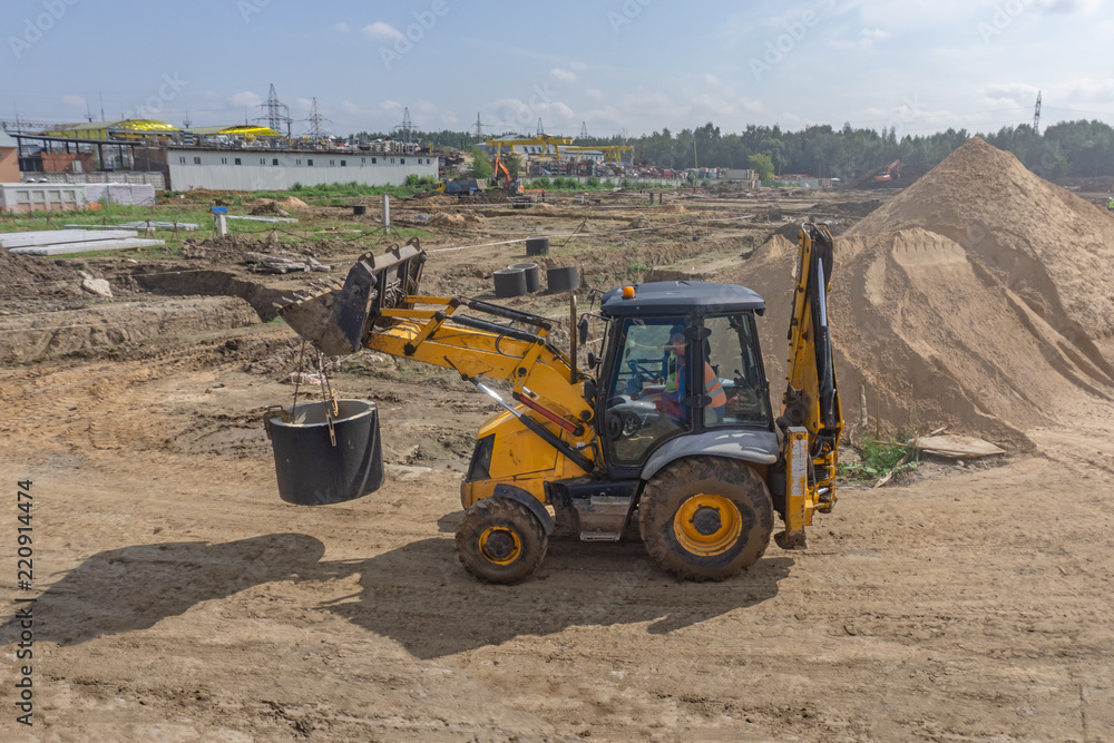 Obraz premium Tractor carries a concrete ring for a well