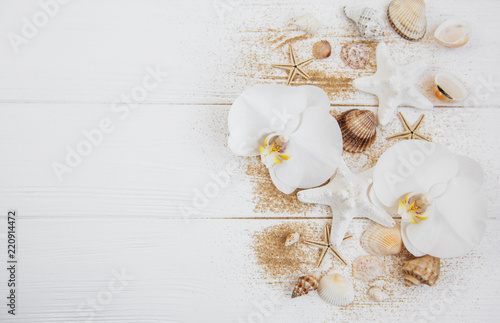 sea shells with sand and orchid flowers