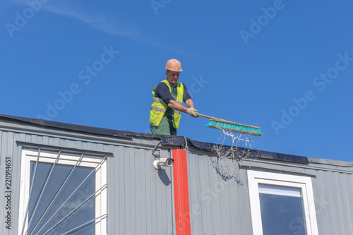 Wallpaper Mural Worker at the construction site cleans the roof of the water with a brush Torontodigital.ca