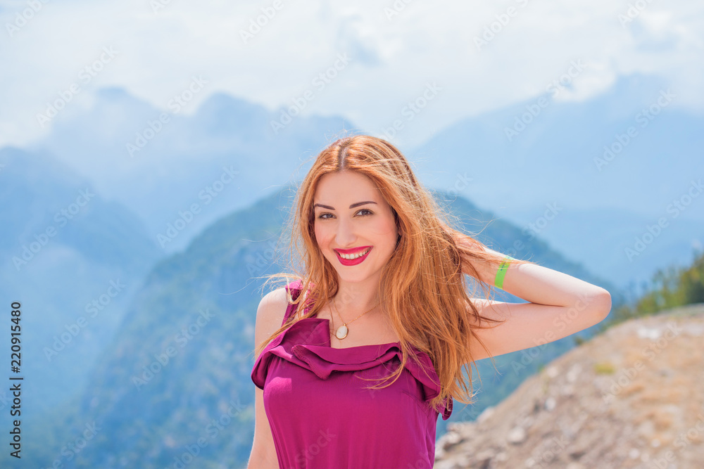 Young woman on the top of rock and looking at the seashore and mountains at colorful view. Landscape with girl, sea, mountain ridges. Travel concept Young woman on the top of rock and looking at the seashore and mountains at colorful view. Landscape with girl, sea, mountain ridges. Travel concept