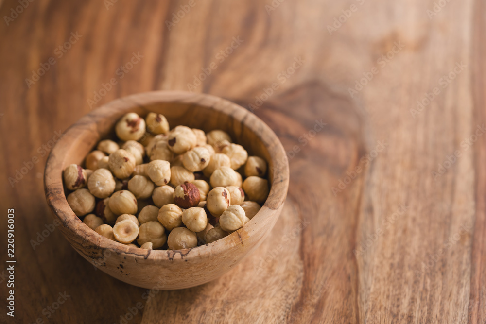 peeled hazelnuts in wood bowl with copy space peeled hazelnuts in wood bowl with copy space