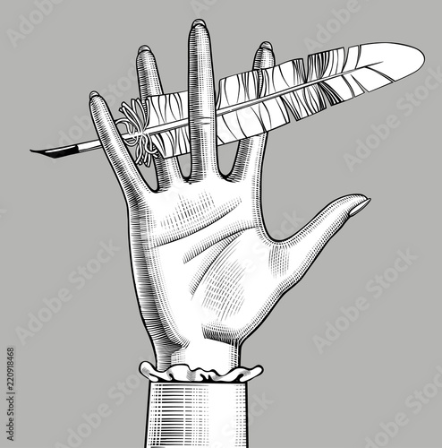 Female hand holding a feather pen