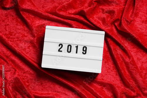 year 2019 on lightbox on red velvet background