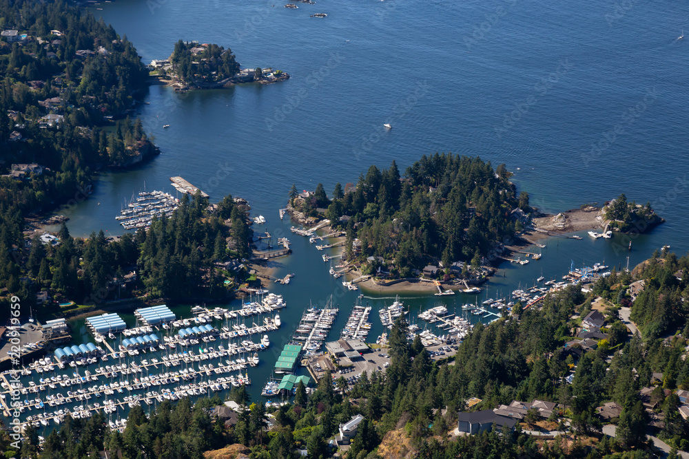 Aerial view of Marina and Residential homes by the ocean shore. Taken in Horseshoe Bay, West Vancouver, BC, Canada.