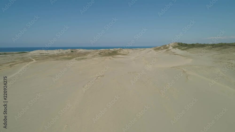 Aerial view of beautiful lonely beach and Paoay sand dune. Philippines, Luzon. Sand dunes near to the sea with sky. Ilocos Norte. Aerial view of beautiful lonely beach and Paoay sand dune. Philippines, Luzon. Sand dunes near to the sea with sky. Ilocos Norte.