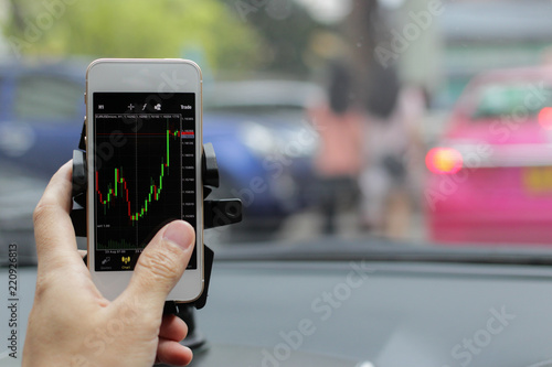 business man trade and check graph forex in stock market exchange money on mobilephone during drive car, investor concept.